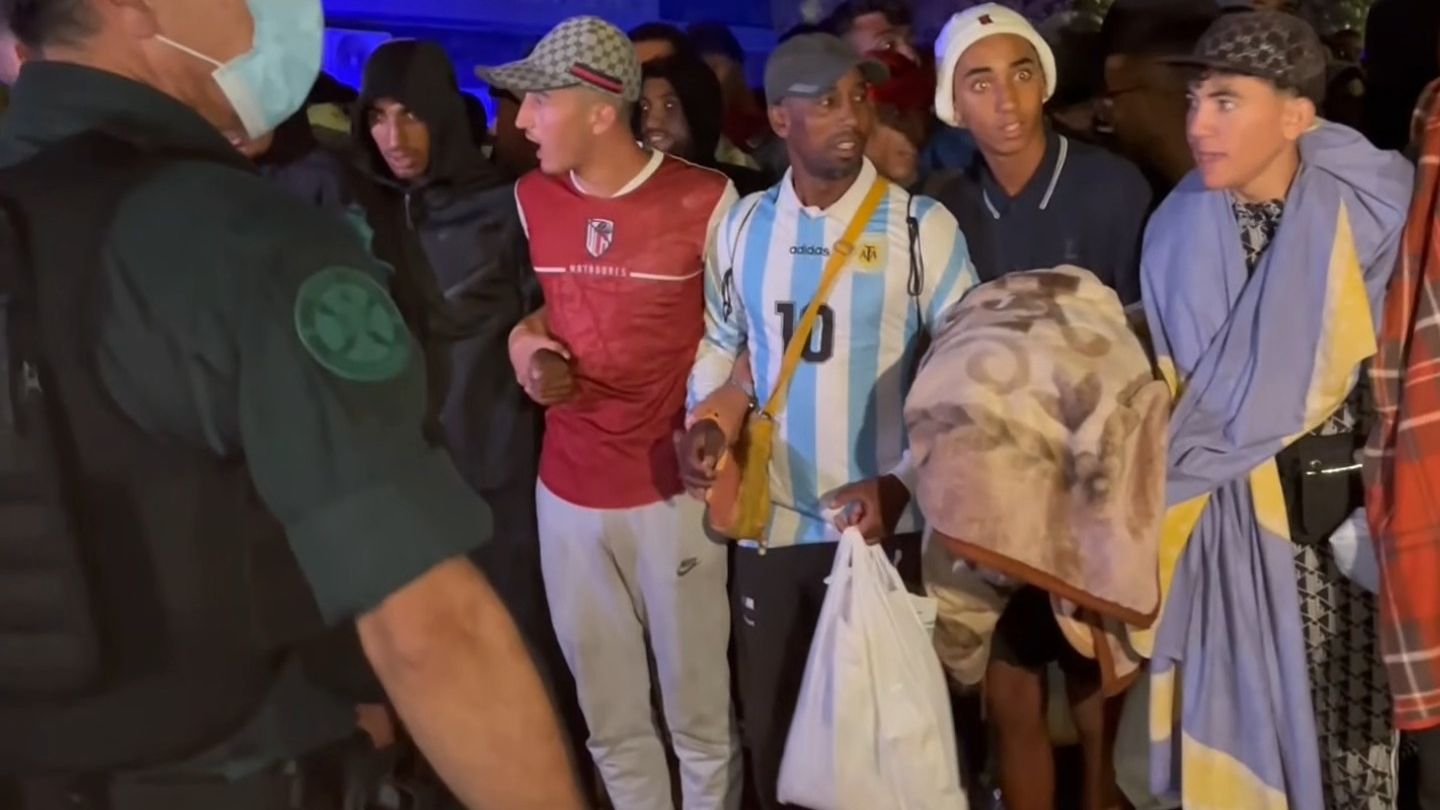 Una avalancha de migrantes se salta el cordón policial y crea el caos durante el traslado de las playas al Puerto de Ceuta
